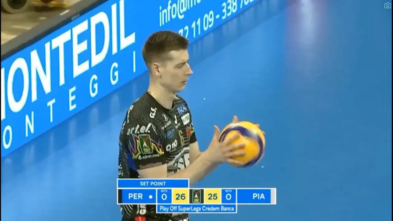 Siatkarz z piłką w rękach podczas meczu włoskiej ligi siatkówki. Wynik 26:25 dla PER.