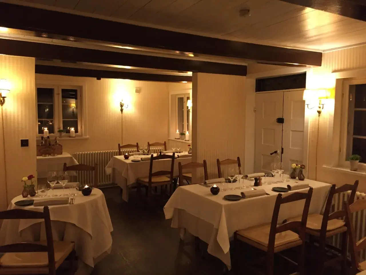 Mysig restaurangmiljö med dukade bord och levande ljus. Perfekt för en middag på en av Odenses många restauranger.