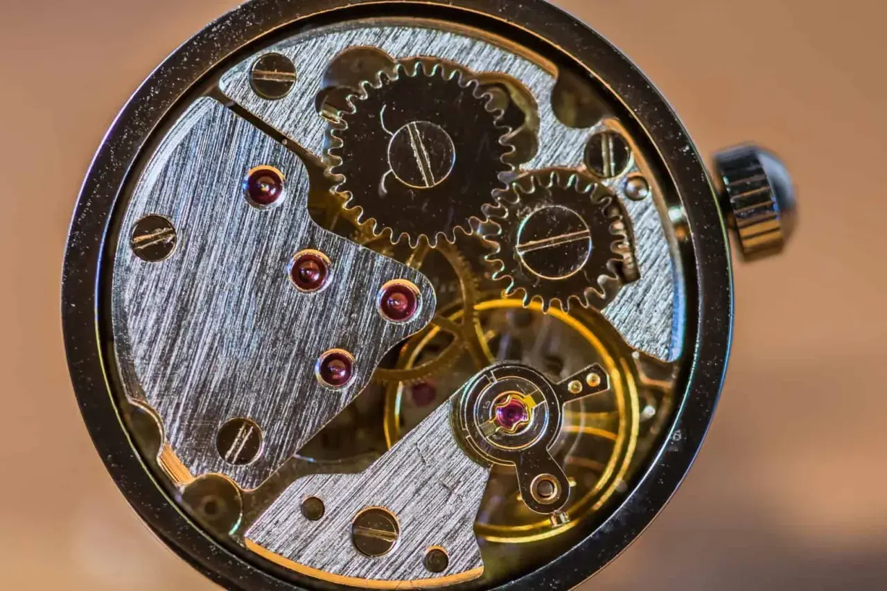 Makrofotografia sprzętu zegarka: precyzyjne koła zębate, rubiny i metalowe elementy tworzą skomplikowany mechanizm.