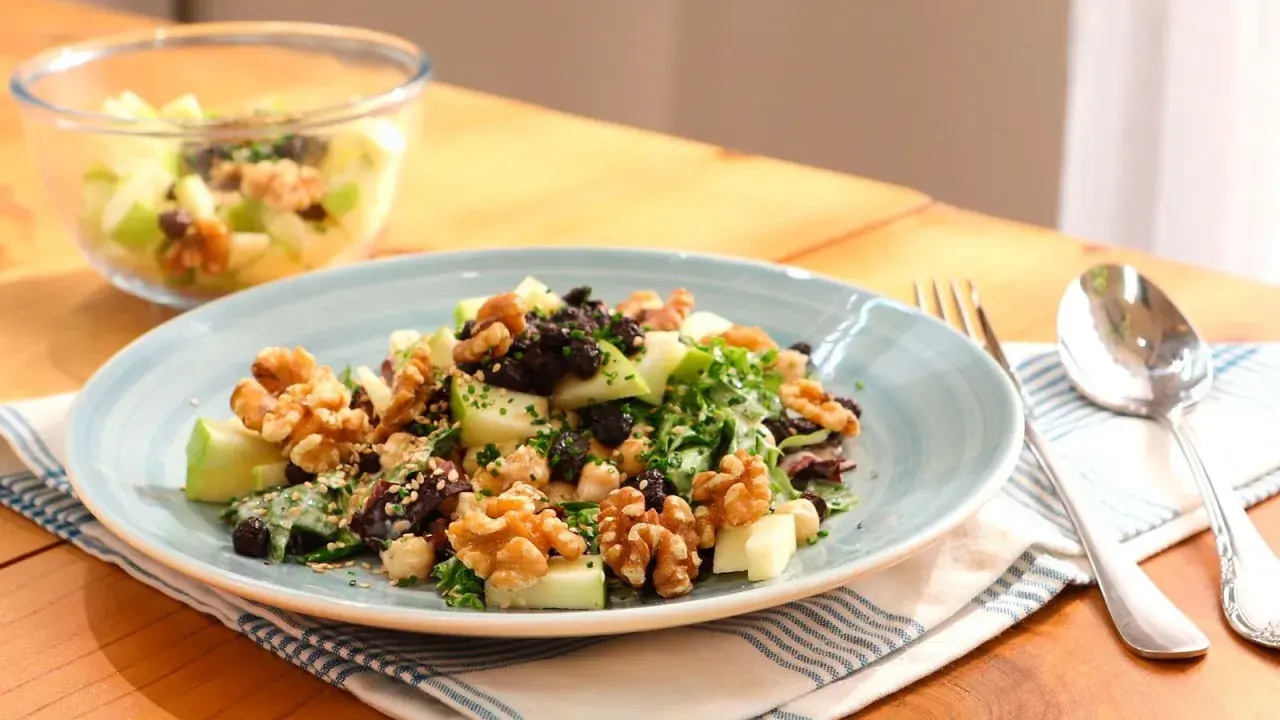 Deliciosa ensalada de manzana con nueces, pasas y semillas. Un plato fresco y nutritivo.