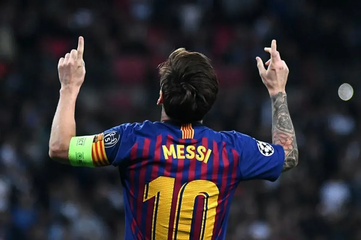 Leo Messi z podniesionymi rękami, w koszulce FC Barcelona z numerem 10. Symbol jego wielkiej historii w klubie.