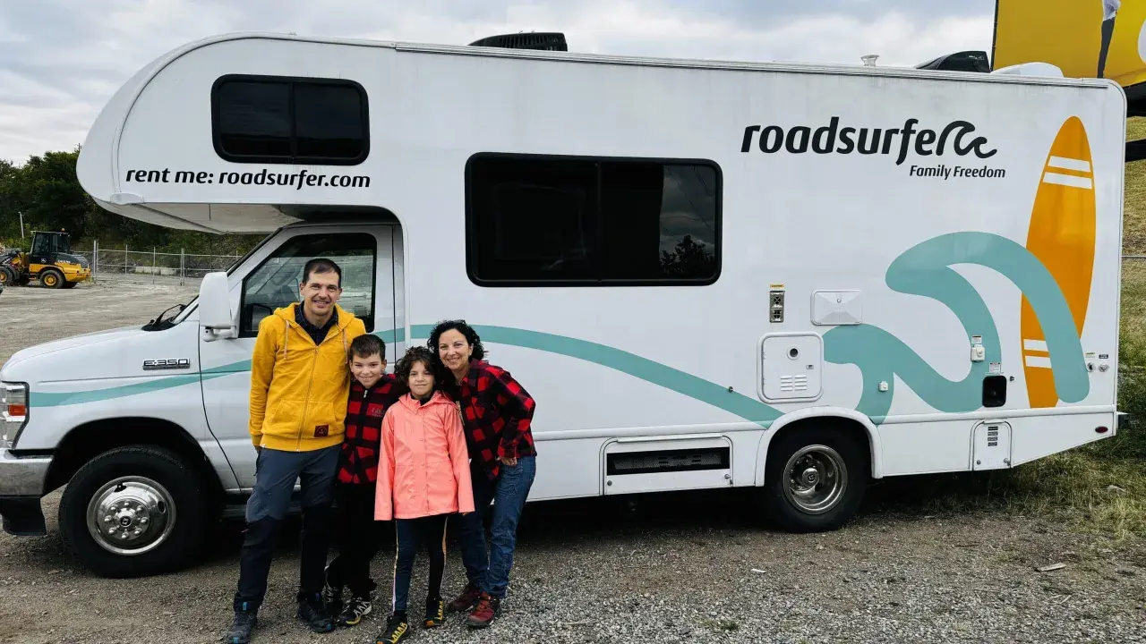 Famille souriante devant un camping-car Roadsurfer prêt pour un road trip Canada. L'aventure commence !
