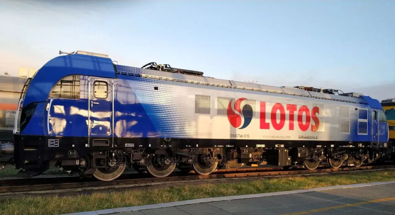 Lokomotywa Dragon 2 z logo LOTOS na tle błękitnego nieba.