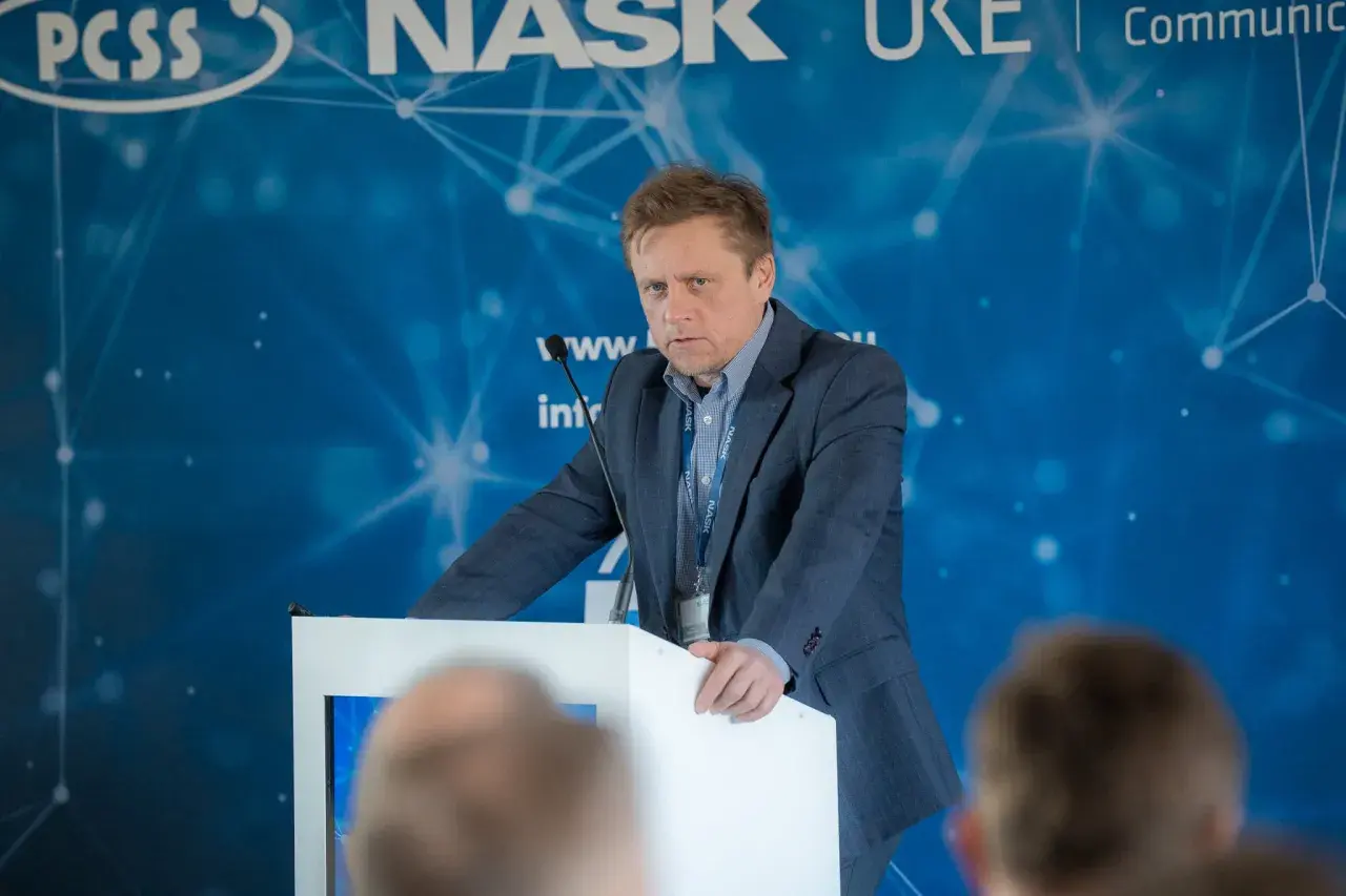 Mężczyzna w garniturze przemawia na konferencji. Dowiadujemy się, ctf co to jest, dzięki jego prezentacji.