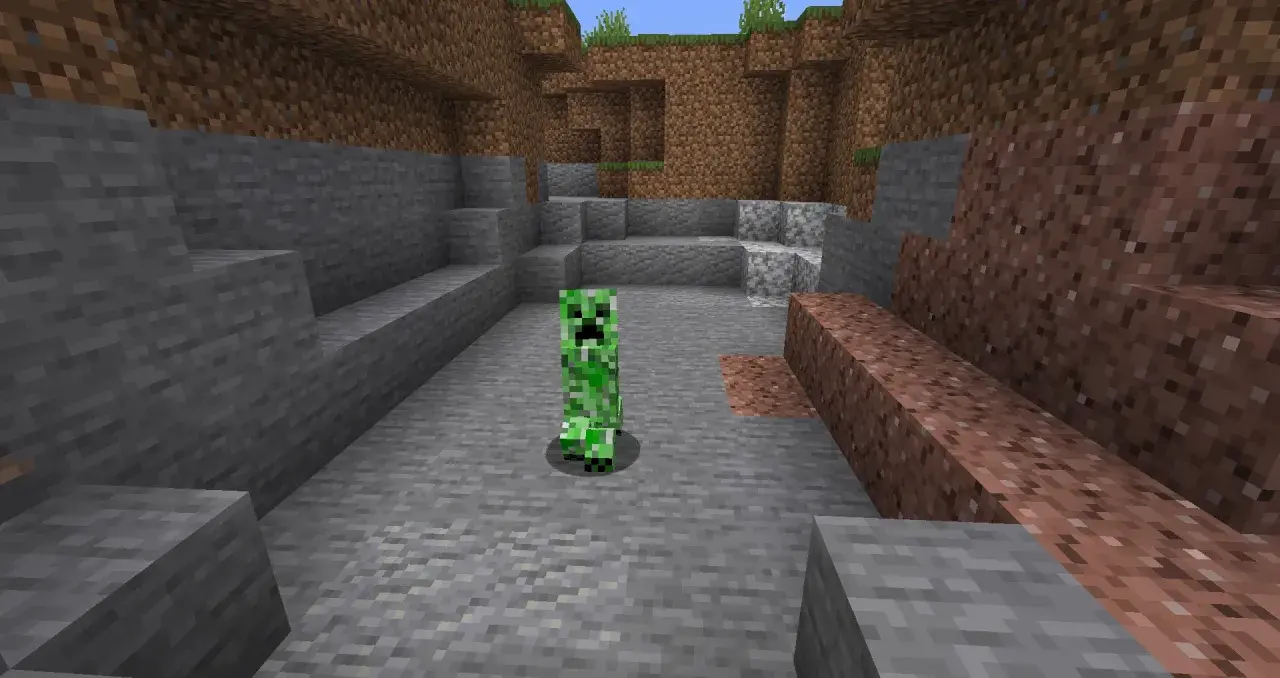 Zielony creeper z Minecrafta stoi na kamienistym podłożu, otoczony przez bloki kamienia i ziemi.