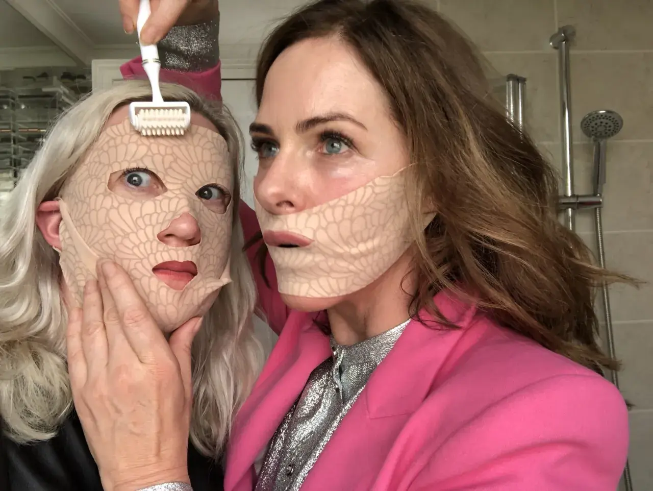 Två kvinnor med ansiktsmasker. En använder en microneedling-roller. Frågan om microneedling hemma hur ofta är relevant för denna typ av behandling.