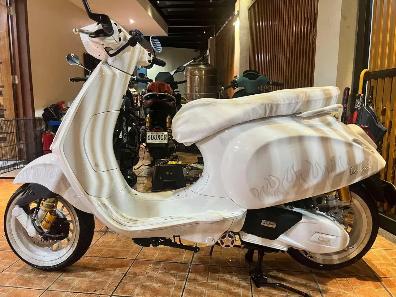 Vespa bianca personalizzata con fiamme, un vero gioiello a 2 tempi pronto a sfrecciare.