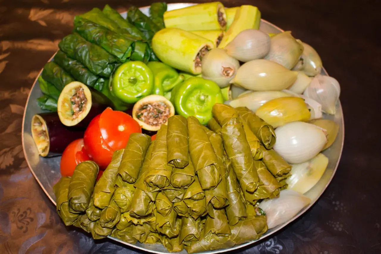 Stor bricka med fyllda vinblad, gröna paprikor, tomater, aubergine, zucchini och lök. Ett härligt dolma recept!