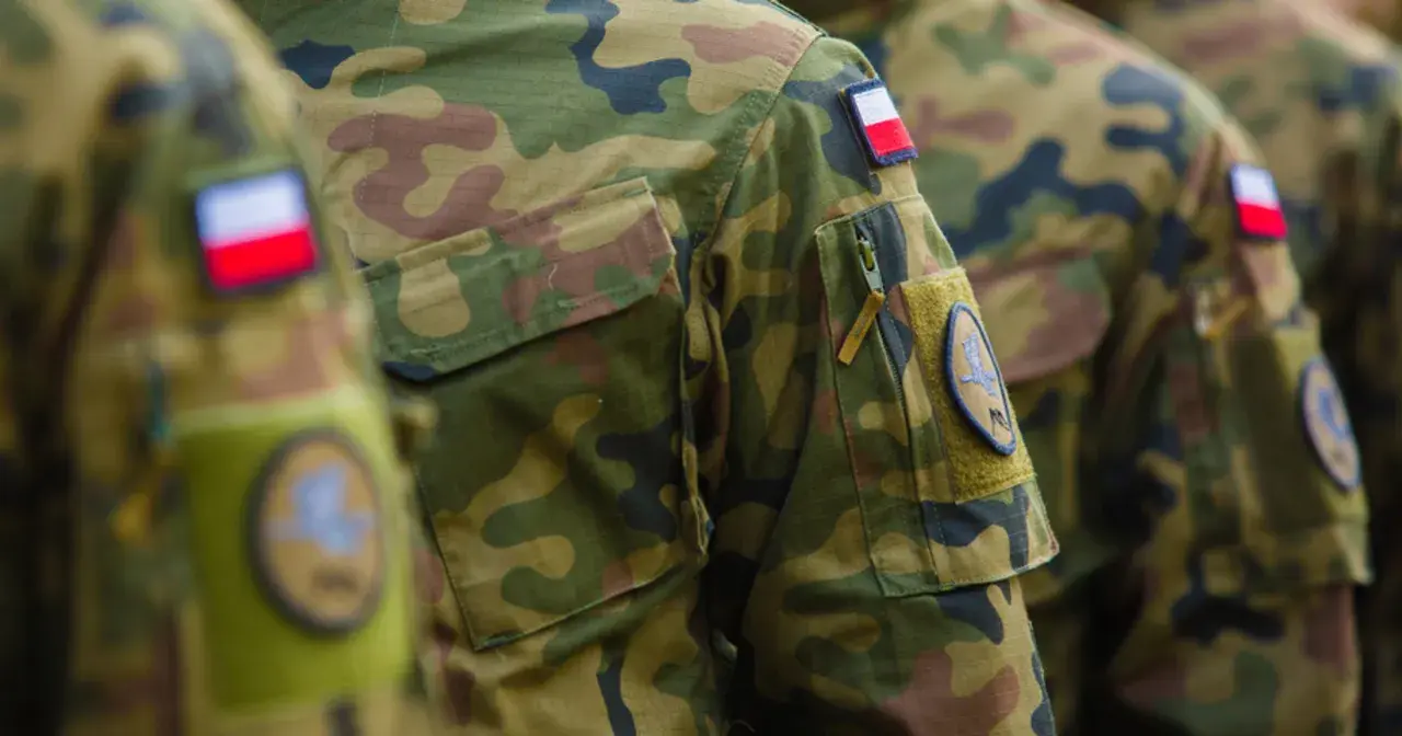 Żołnierz RP w mundurze moro, z naszywką z polską flagą. Dumnie reprezentuje kraj.