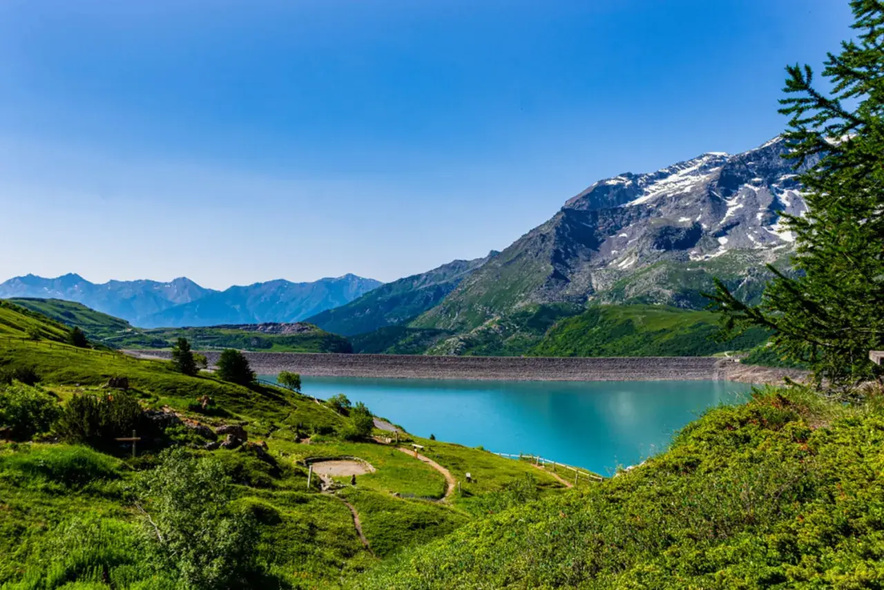 Paysage de montagne avec un lac turquoise, idéal pour savoir que visiter en Auvergne.