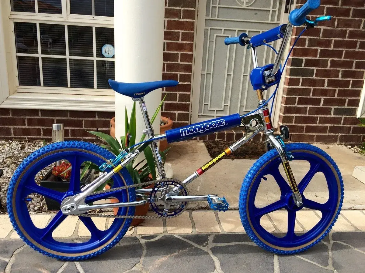 A blue Mongoose Supergoose BMX bike, a classic from the 1980s bicycle brands, with chrome accents and blue mag wheels.