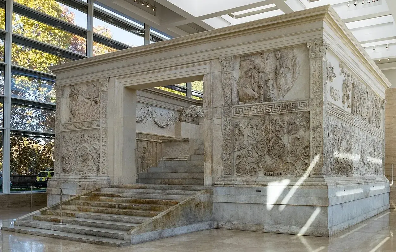 L'Ara Pacis, un capolavoro in marmo, mostra rilievi storici e decorativi. Le sue scalinate conducono a un altare antico, testimone di un'epoca passata.