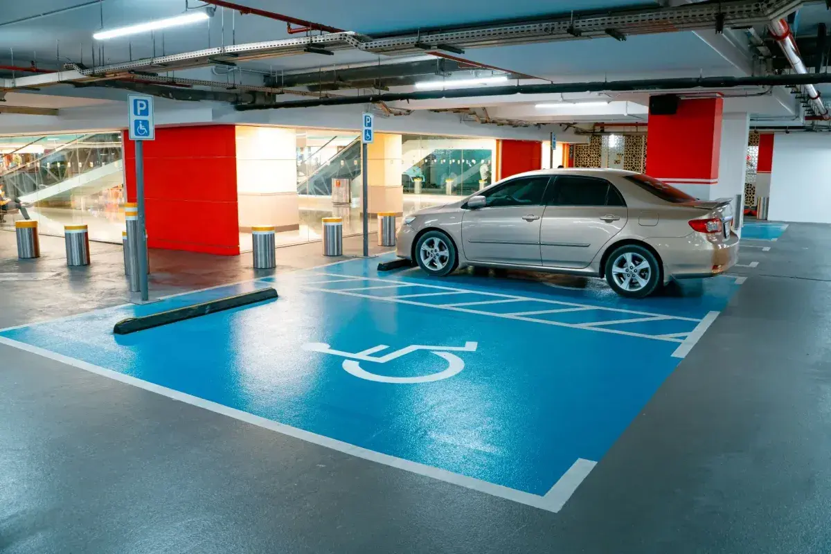 Miejsce parkingowe dla osób z niepełnosprawnościami, symbol wózka inwalidzkiego. Ułatwienia dla niepełnosprawnych przy rejestracji samochodu.