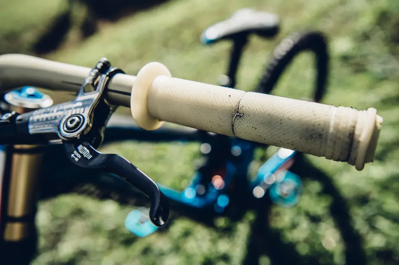 Jasne, oto opis:

Gripy do MTB – jasne, z wyraźną fakturą, idealne do pewnego chwytu. Widoczna dźwignia hamulca.