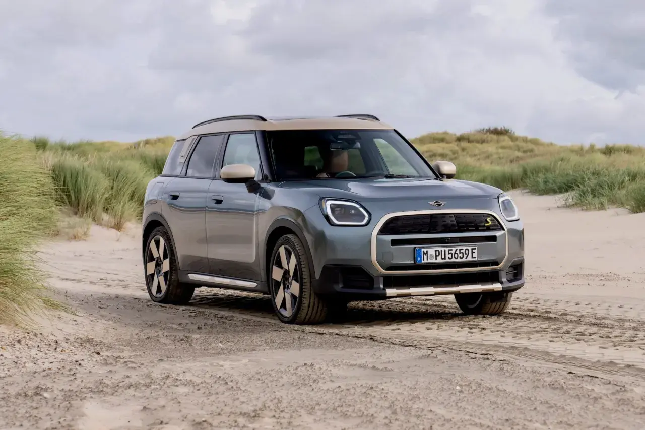 Grå Mini Countryman på sandig väg vid en strand. En spännande mini countryman test i en unik miljö.