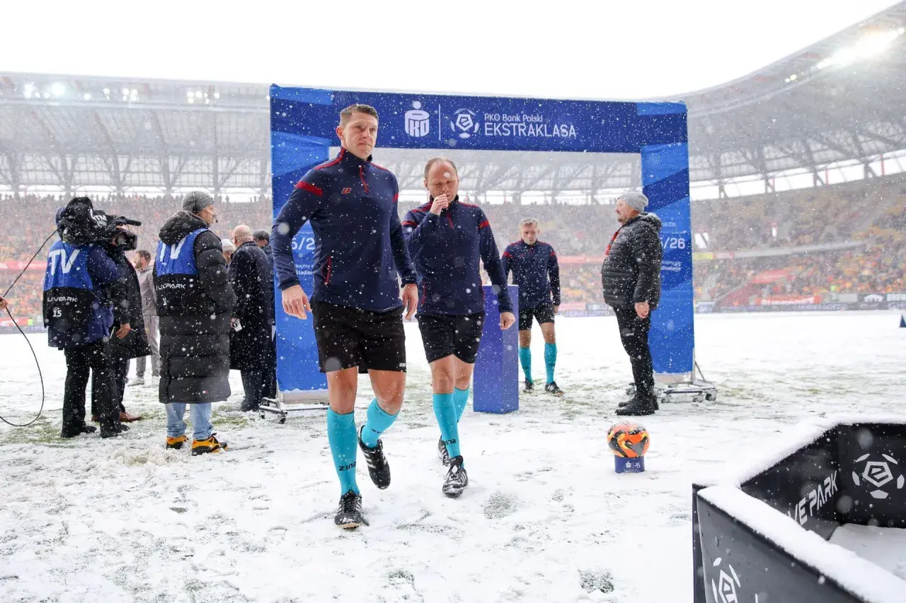 Sędziowie w śnieżny dzień wchodzą na boisko przed meczem Jagiellonia Białystok – GKS Katowice.