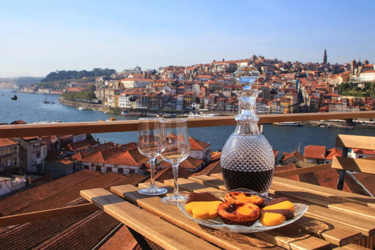 Un bicchiere di **douro vino** e dolci su un tavolo con vista su Porto.