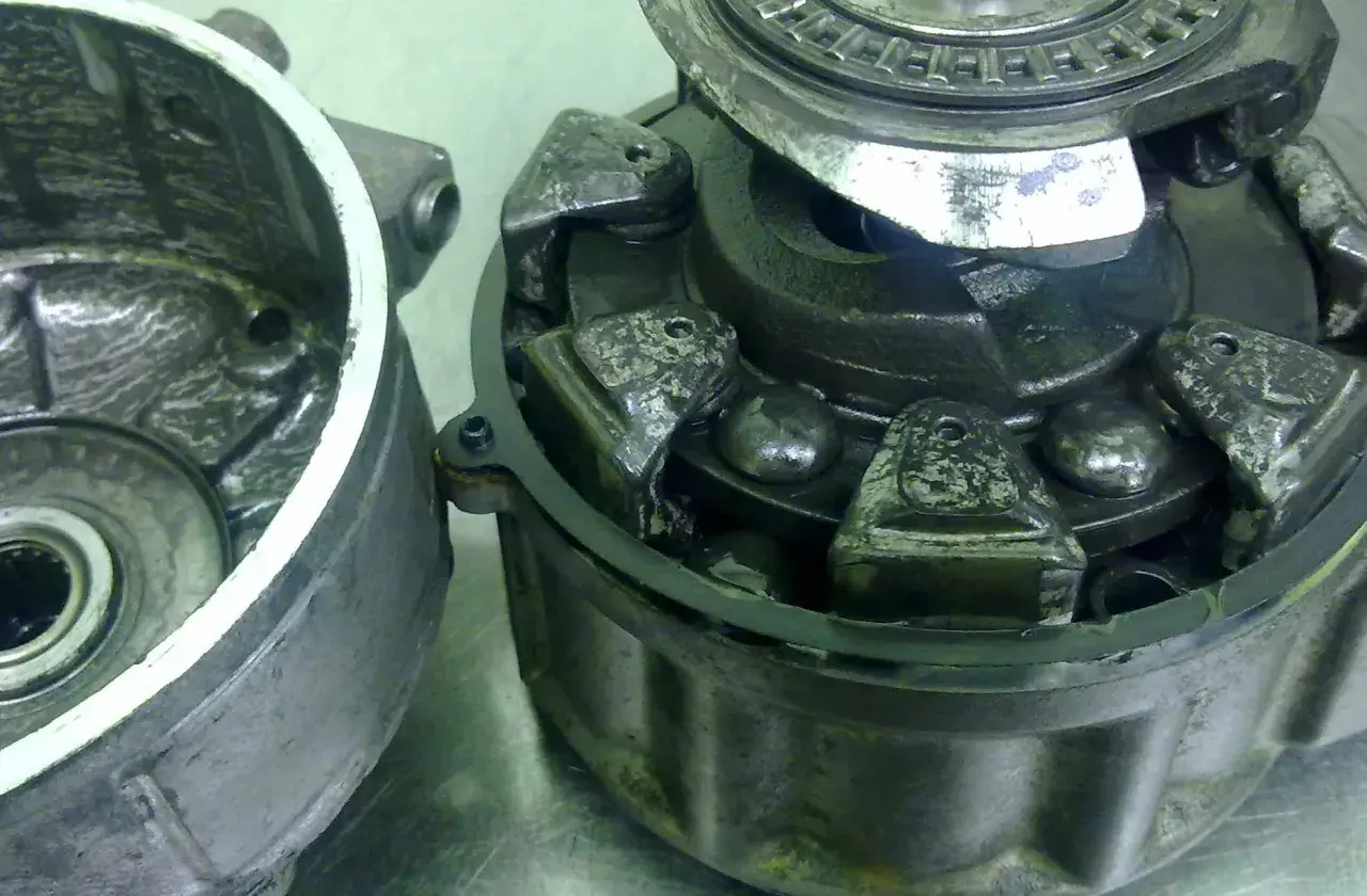 Rozłożone koło pasowe sprężarki klimatyzacji z widocznymi elementami mechanicznymi i łożyskami.