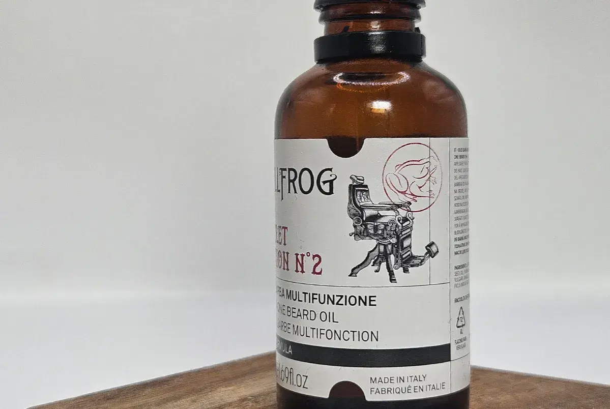 Olej do brody Bullfrog z wizerunkiem żaby i fotela fryzjerskiego.