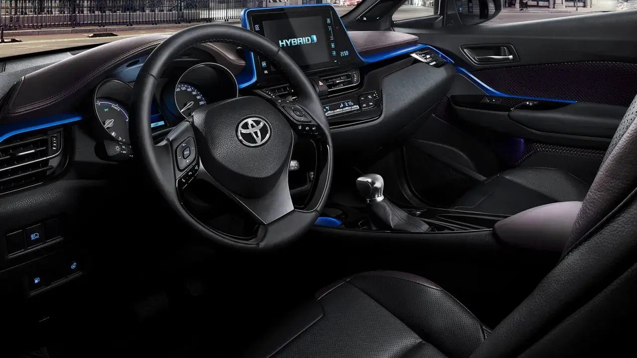 Interiör i en Toyota C-HR Hybrid. En del tycker att den blå accentbelysningen är en charmig detalj, andra ser det som ett potentiellt toyota chr problem.