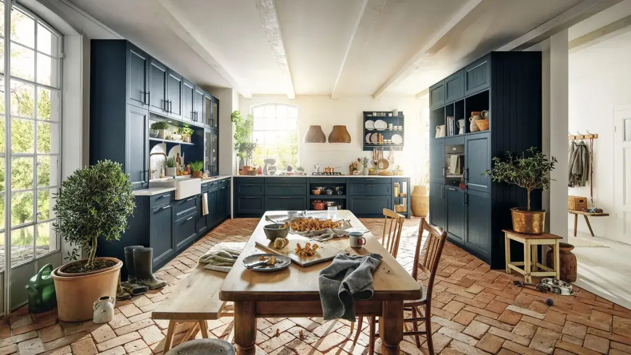 Geräumige Küche im mediterranen Landhausstil mit dunklen Schränken, Holztisch und Terrakotta-Boden.