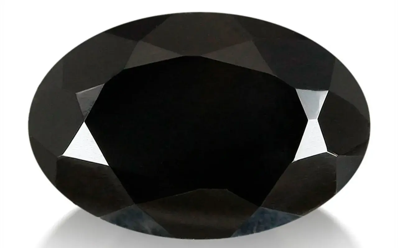 Espinela negra ovalada, facetada, con reflejos de luz que resaltan sus propiedades.