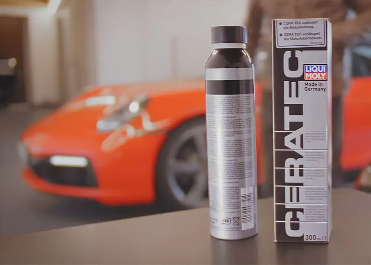 Dwa opakowania LIQUI MOLY CERA TEC obok pomarańczowego samochodu sportowego. Produkt zapewnia optymalną moc i dłuższą żywotność silnika.