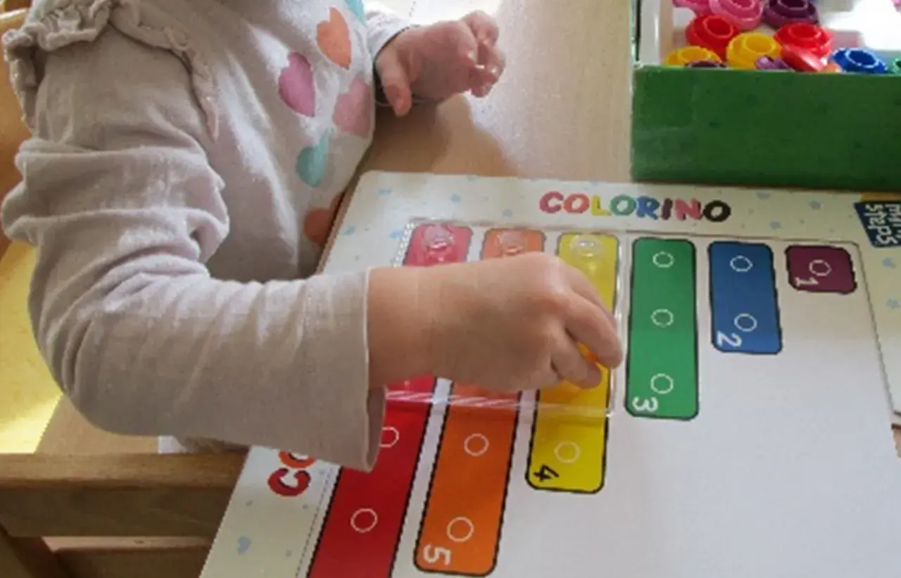 Ein Kind lernt im Kindergarten spielerisch Formen und Farben mit dem Spiel "Colorino".