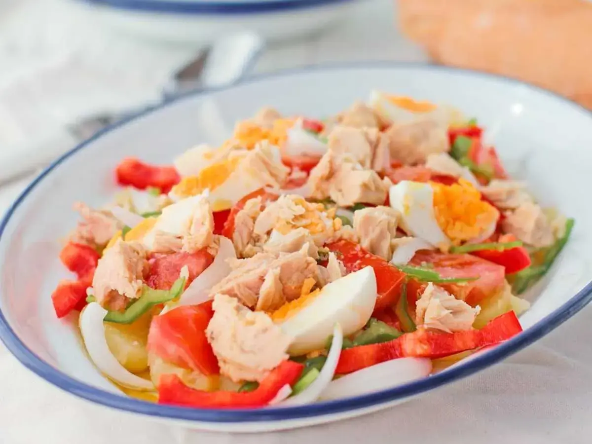 Ensalada campera con atún desmigado, huevo duro, tomate, pimiento y cebolla. Un plato fresco y completo.