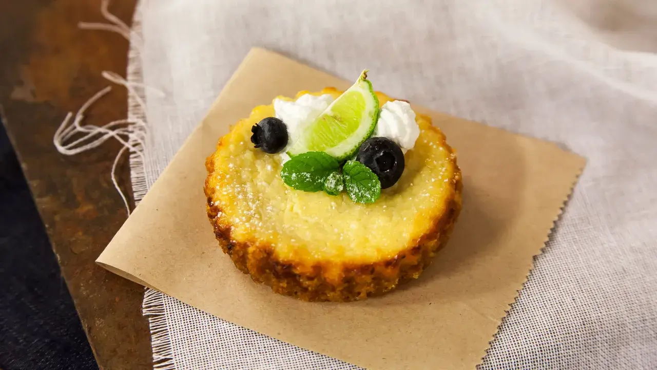 Deliciosa torta de ricota, decorada con arándanos, menta, crema y una rodaja de lima.