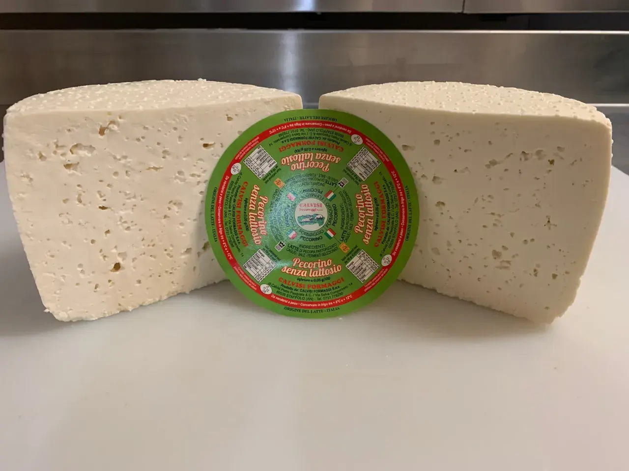 Due forme di pecorino senza lattosio, una con etichetta circolare verde al centro.