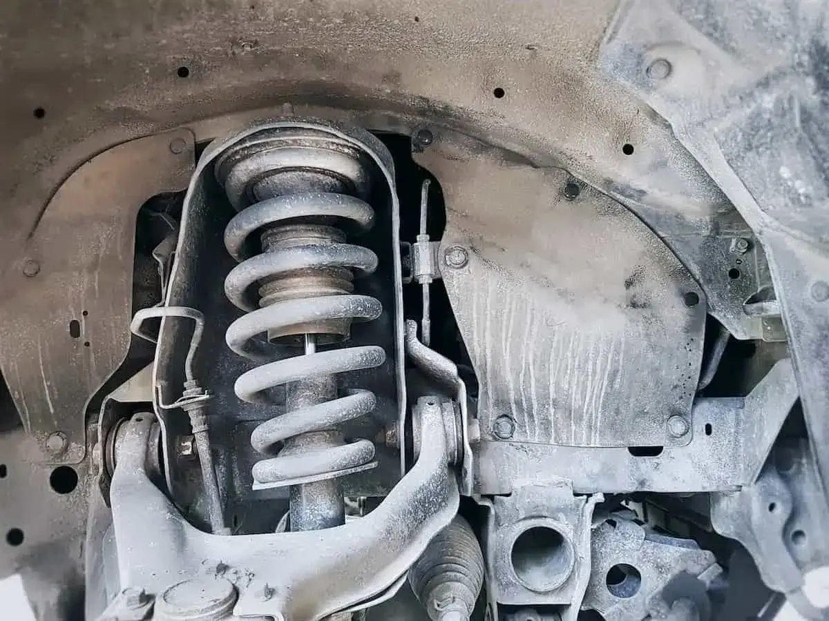 Primer plano de un amortiguador de coche, parte esencial para el confort y la seguridad.