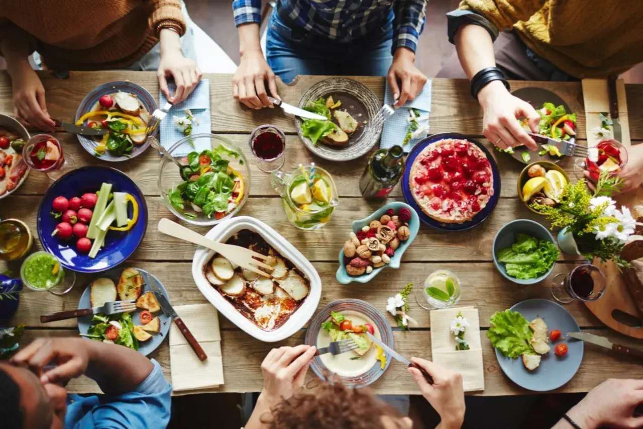 Leckeres Essen auf dem Tisch, aber was hilft gegen Appetit? Nüsse und frisches Gemüse sind eine gesunde Wahl.
