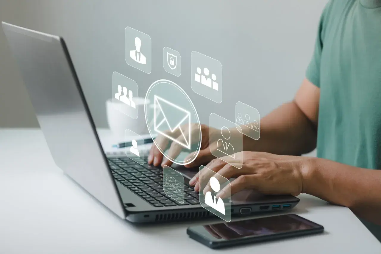 Man typing on laptop, with icons representing communication and security, suggesting a secure correo electrónico certificado.
