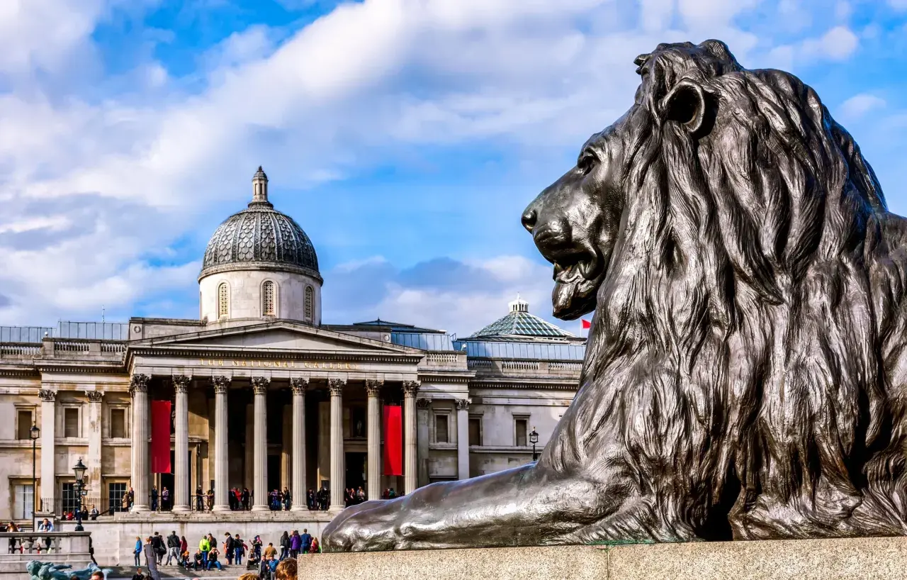 Lew przed monumentalnym budynkiem Muzeum Narodowego w Londynie.