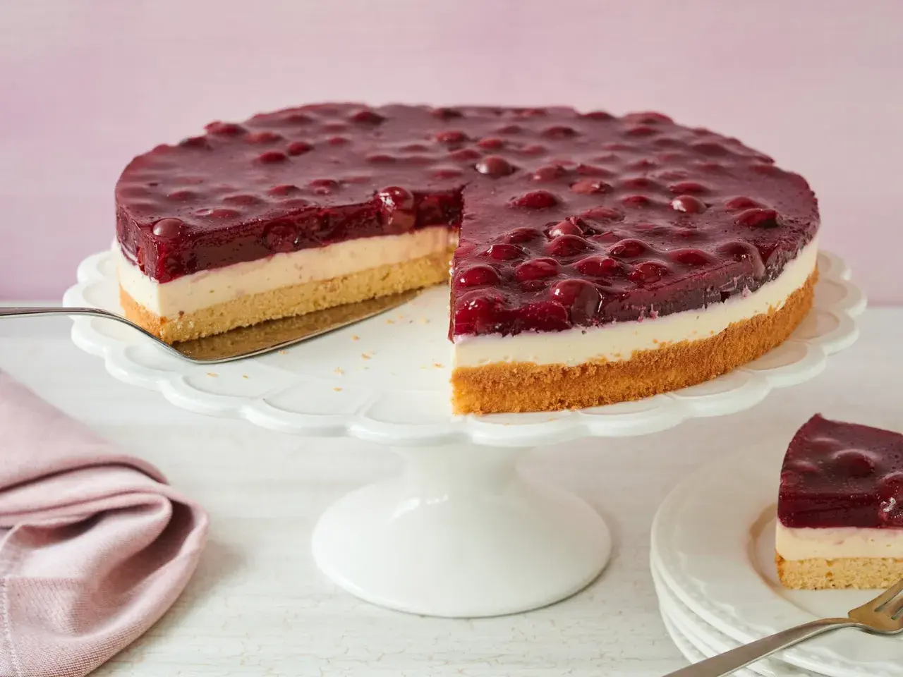 Ein saftiger Kirsch Schmand Kuchen mit einer cremigen Schicht und einem Boden aus Biskuit, bedeckt mit Kirschen in Gelee.