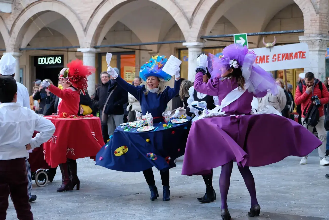 Persone in costume colorato danzano durante il carnevale di Ascoli.