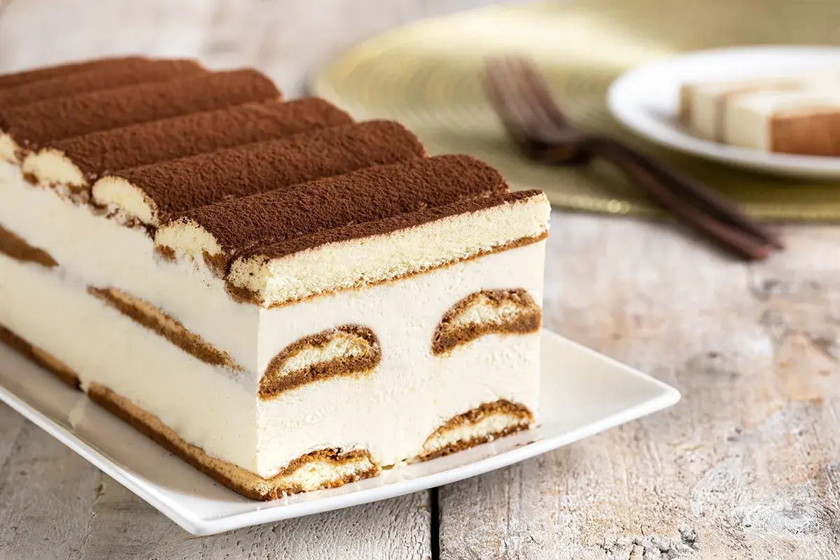 Tiramisù cremoso, uno dei dolci senza glutine perfetti per ogni occasione. Strati di savoiardi e crema, spolverati di cacao.
