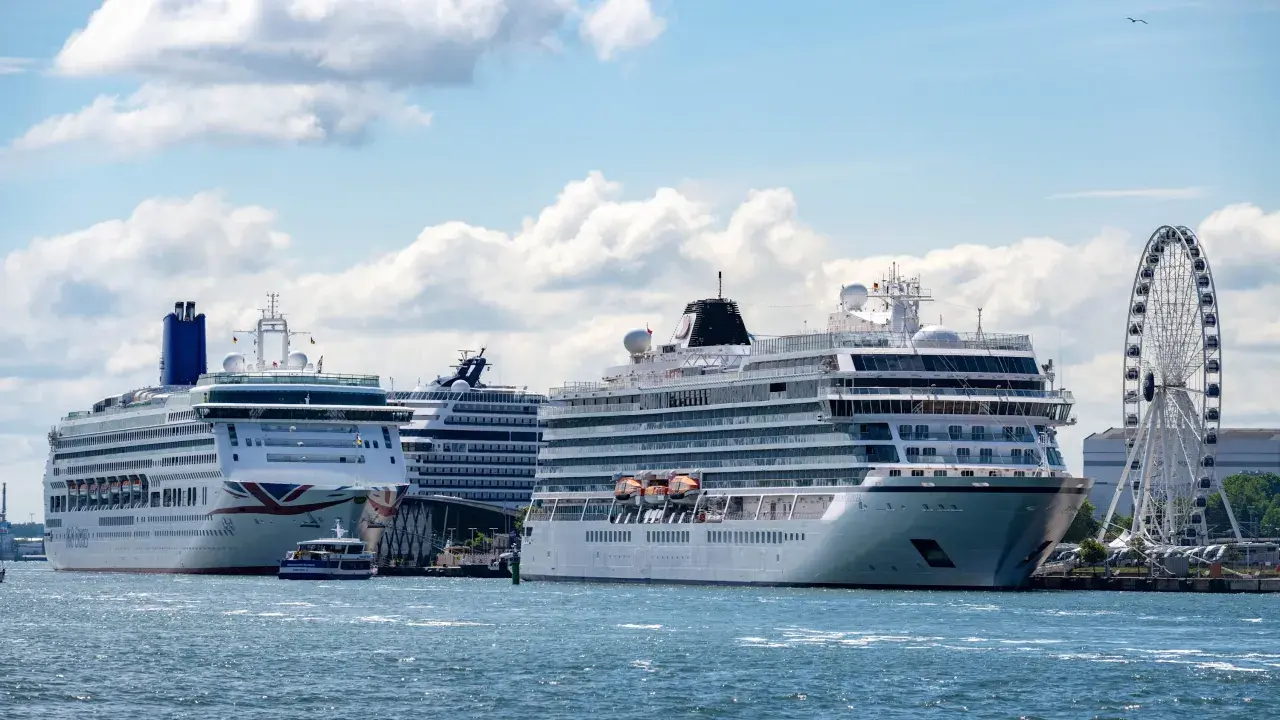 Mehrere Kreuzfahrtschiffe liegen im Hafen, ein Zeichen für die florierende Branche und gute Aussichten für Kreuzfahrt Aktien.