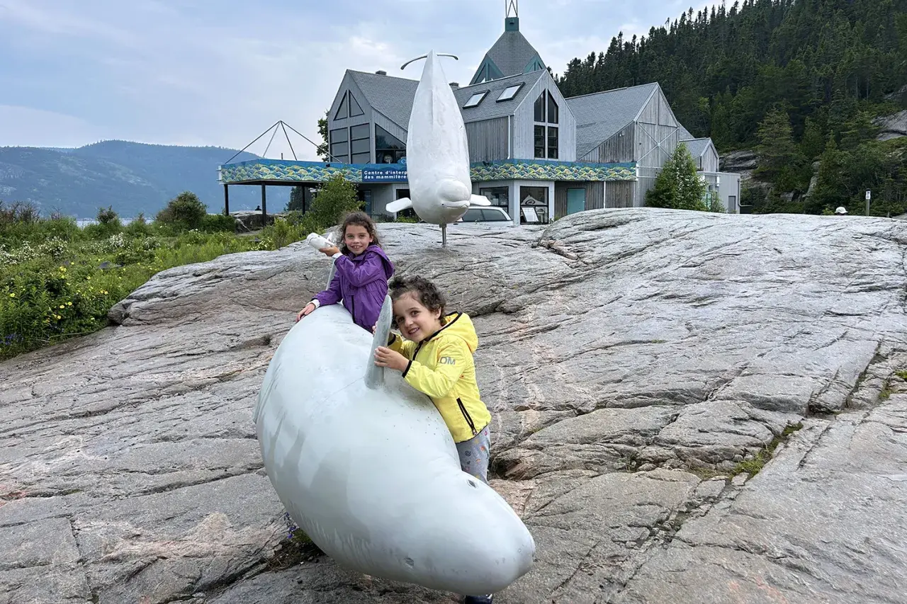 Due bambine giocano con sculture di balene a Canada orientale, vicino a un centro di interpretazione.