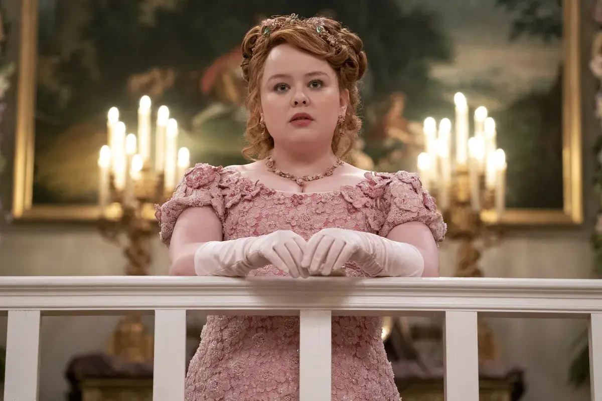 Penelope Featherington w różowej sukni z kwiatowymi zdobieniami, przygotowuje się na bal w Bridgertonowie sezon 3.