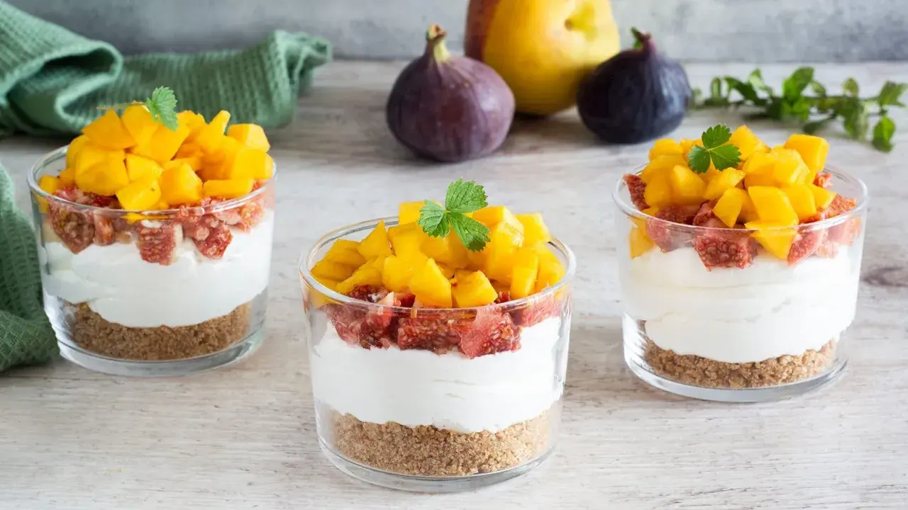 Deliziosi bicchieri con ricotta mousse, crumble, fichi e mango fresco. Un dolce estivo perfetto.