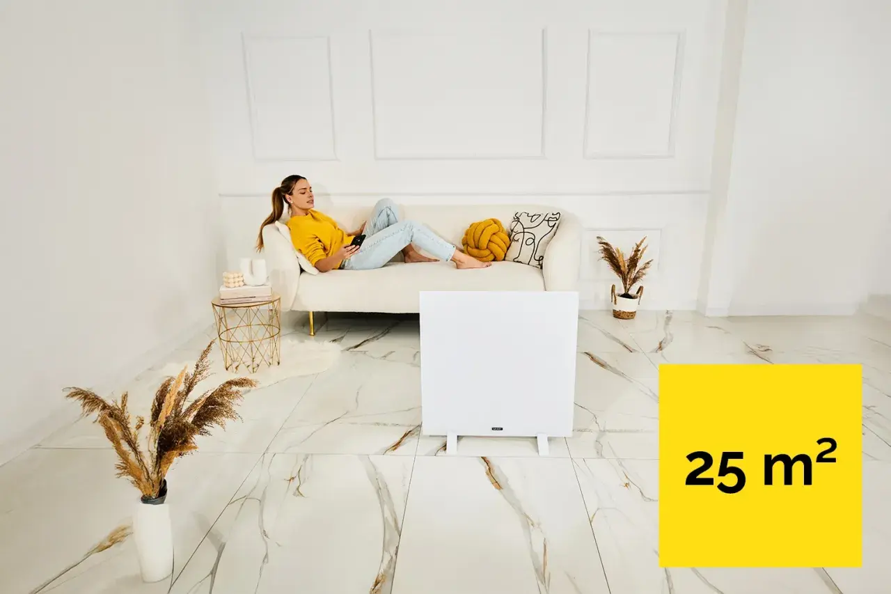 Kobieta relaksuje się na kanapie, podczas gdy panel grzewczy na podczerwień ogrzewa pomieszczenie 25 m².