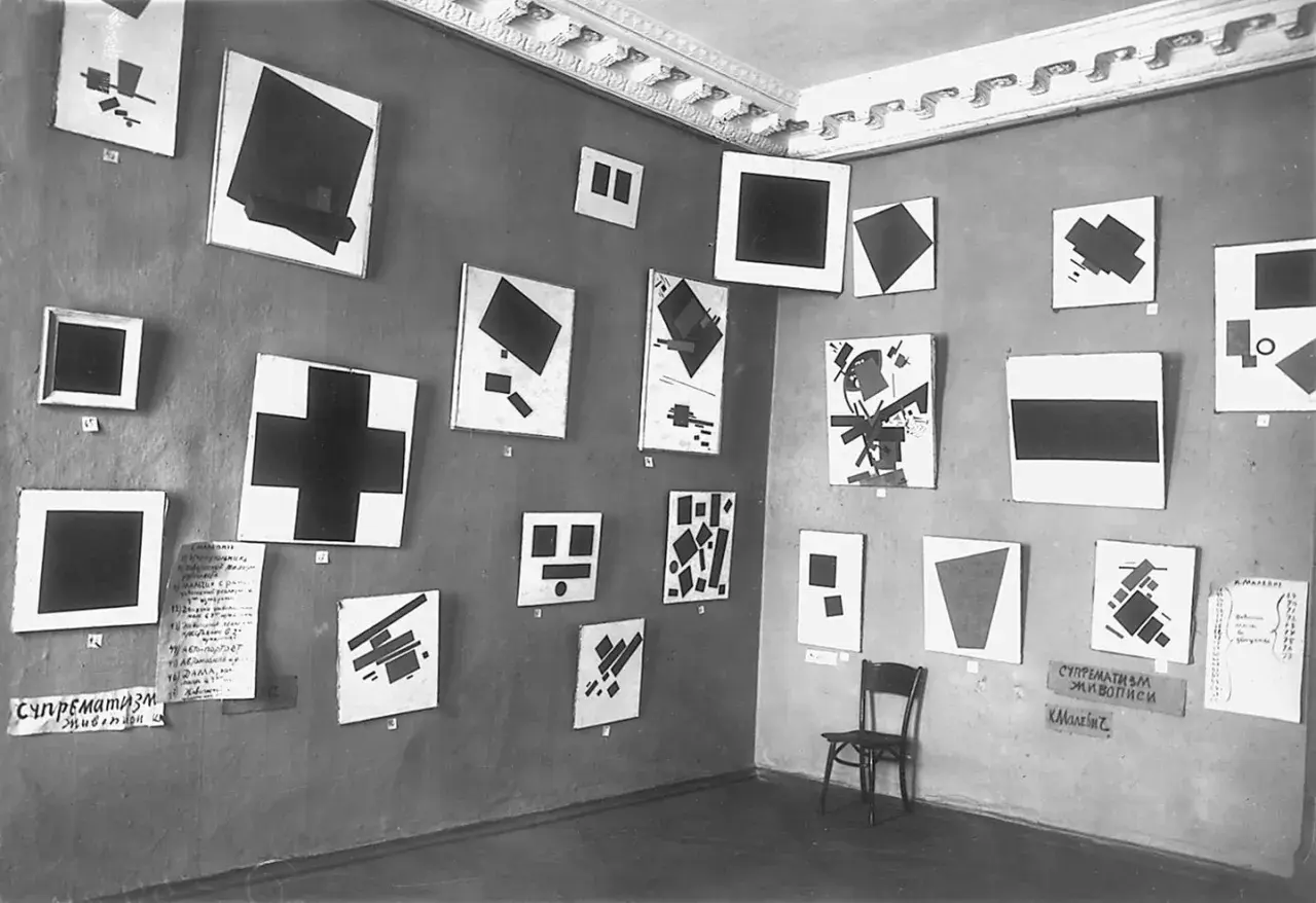 Eine Galerie zeigt Werke des Suprematismus, darunter viele schwarze Quadrate und andere geometrische Formen.