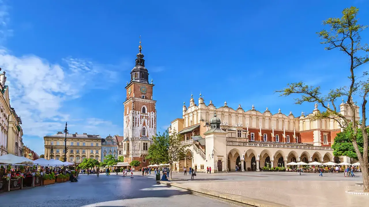 Rynek Główny w Krakowie, z Sukiennicami i wieżą Ratuszową, tętni życiem. Stare miasto w Krakowie zachwyca architekturą i atmosferą.