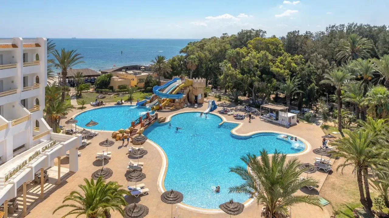 Basen z wodnymi zjeżdżalniami i palmami przy hotelu Marhaba Royal Salem.