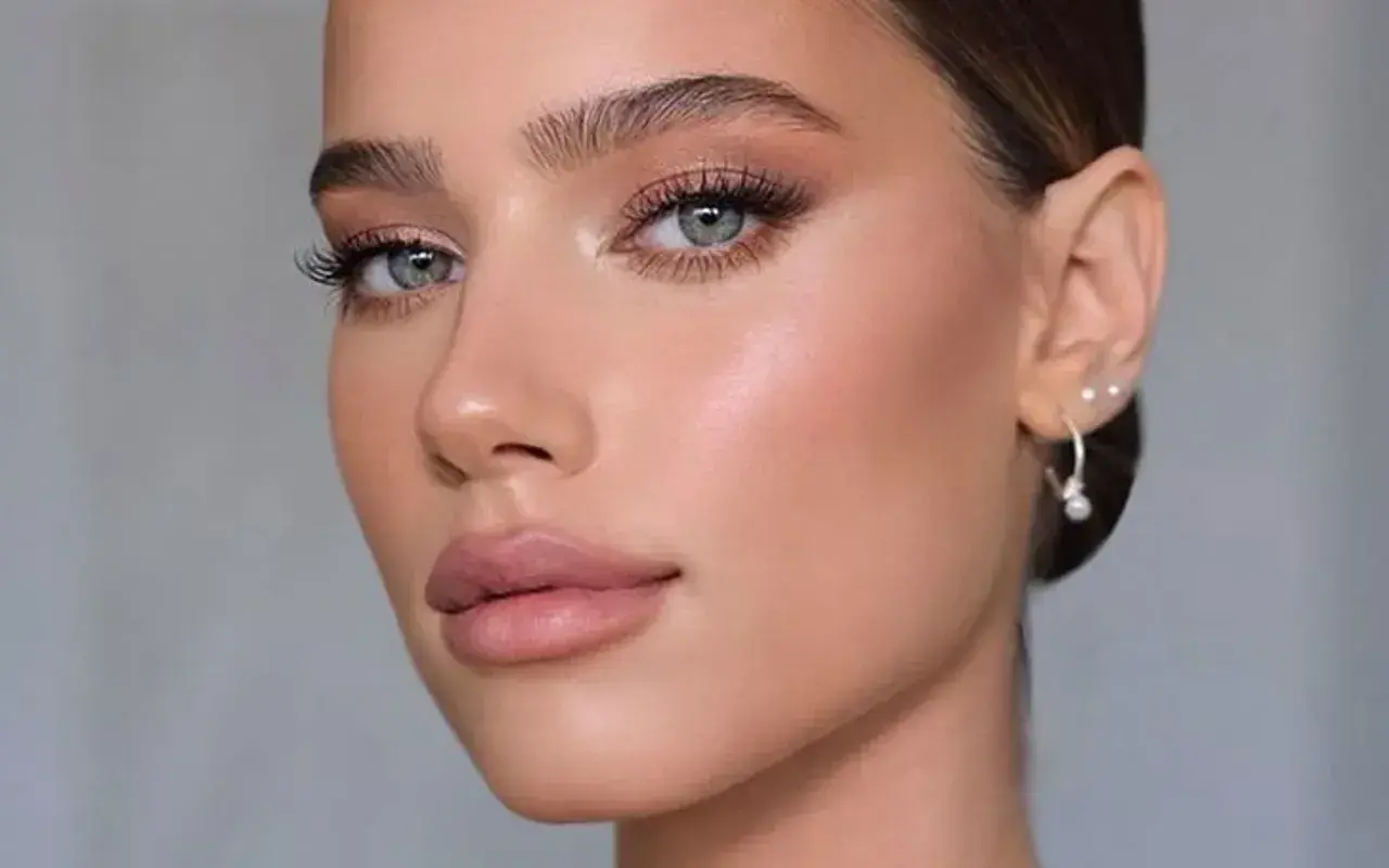 Viso di donna con trucco cerimonia impeccabile: occhi luminosi, labbra nude e pelle radiosa. Perfetto per un evento speciale.