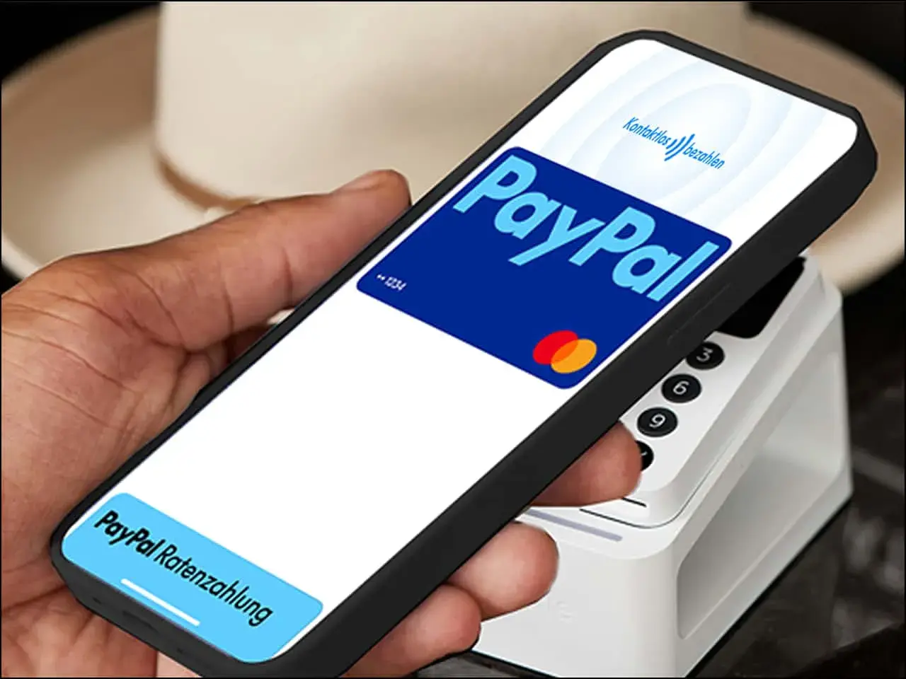Hand hält Smartphone mit PayPal-Logo und "Kontaktlos bezahlen" für eine schnelle Transaktion. Unten: "PayPal Ratenzahlung".