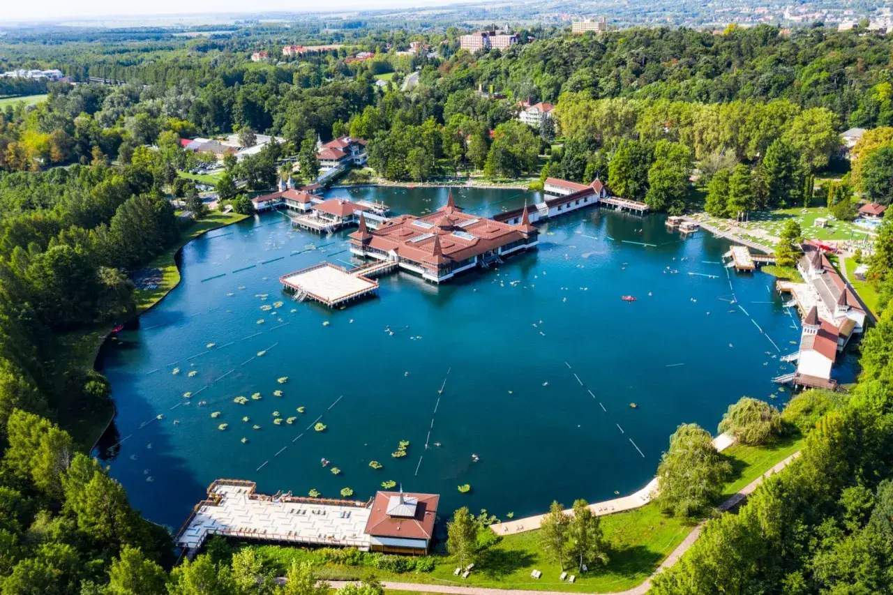 Termalne jezioro z architekturą w stylu zamkowym, otoczone zielenią. To jedno z najpiękniejszych miejsc nad Balatonem, gdzie można odpocząć i skorzystać z kąpieli.