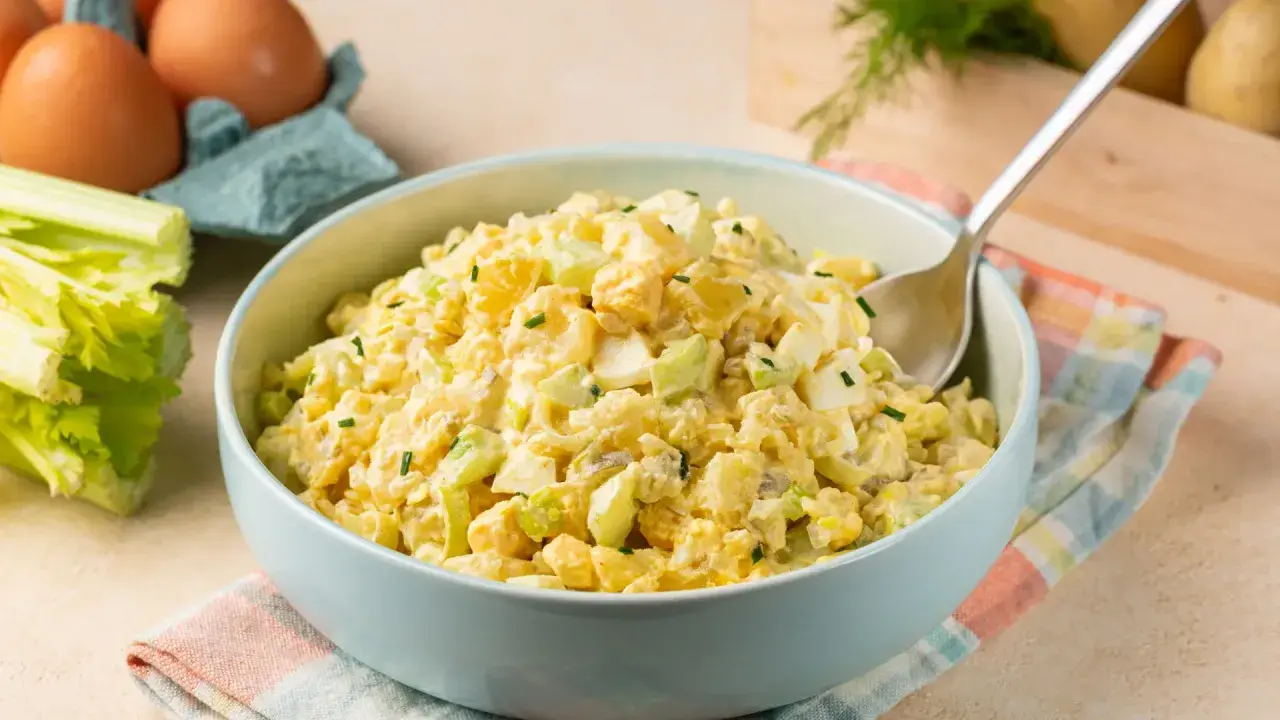 Deliciosa ensalada de apio y manzana, cremosa y fresca, con trozos de huevo duro y patata.